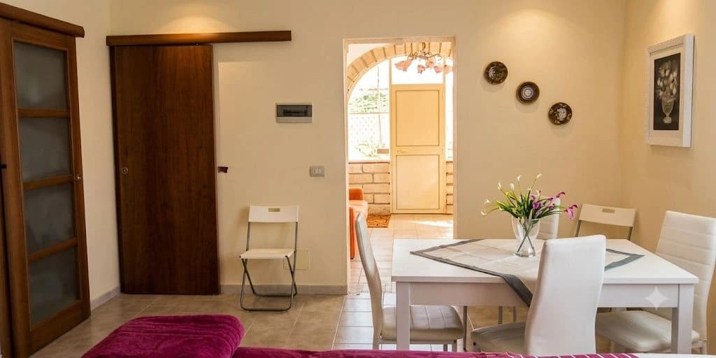 La sala da pranzo della Casa del Nonnino, con tavolo apparecchiato e sedie