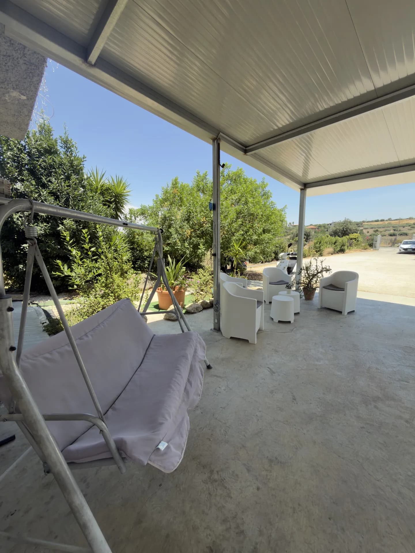 La veranda con poltrone e dondolo, affacciata sul verde